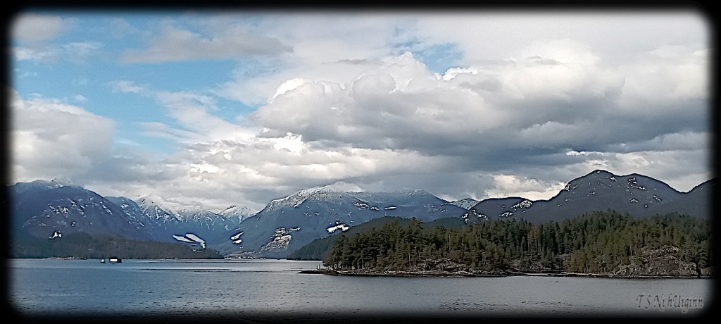 Snowy Peaks behind Island taken by Salish photographer TS Ni hUiginn