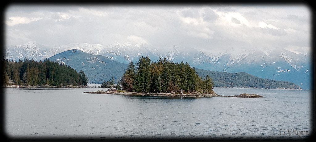 Snowy Peaks behind Island taken by Salish photographer TS Ni hUiginn