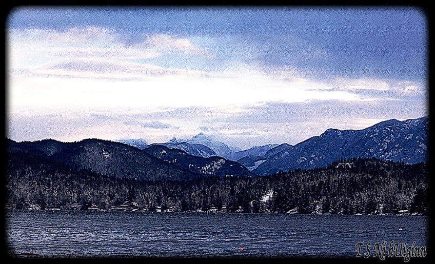 A photograph taken by TS Ni hUiginn of snowy mountain peaks beside the Salish Sea.